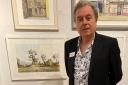 Frank Collict stands next to his work at the Mall Gallery in London