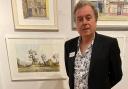 Frank Collict stands next to his work at the Mall Gallery in London
