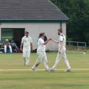 Rhys Lloyd (left) celebrates one of three wickets against Llandaff Thirds