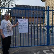 Max Scott-Cook outside the now closed Albert Road Surgery with a sign blaming politicians for the closure