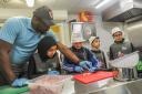 Tony Ogunsulire, Director of Steps4Change, at the Butetown Pavilion, leads a cooking class for children, teaching them life skills. Image: Michael Williams