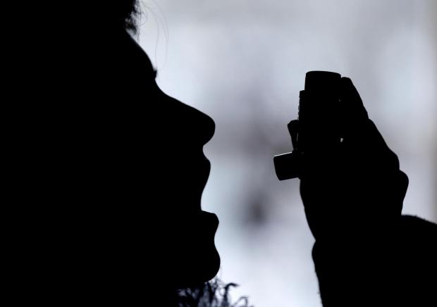 Penarth Times: Silhouette of a person using an inhaler. Credit: Canva